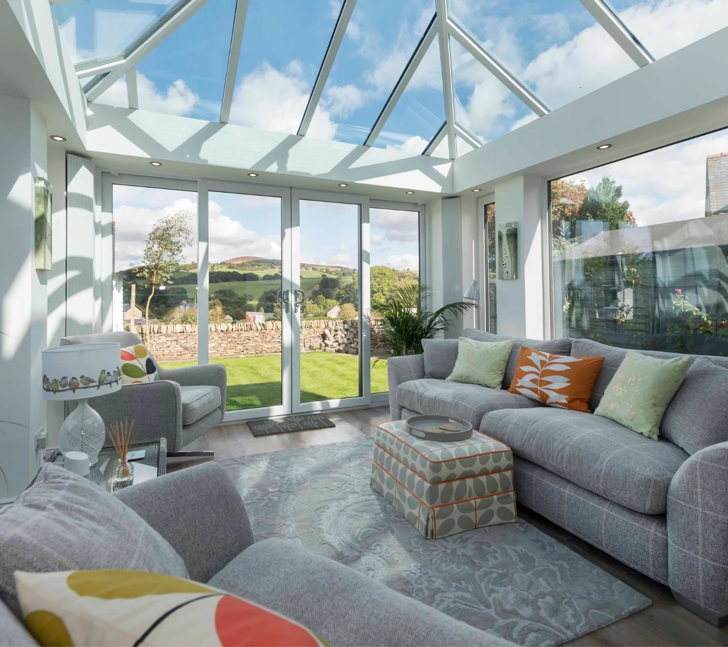 Comfy lounge room with grey sofas in bright and sunny backrgound