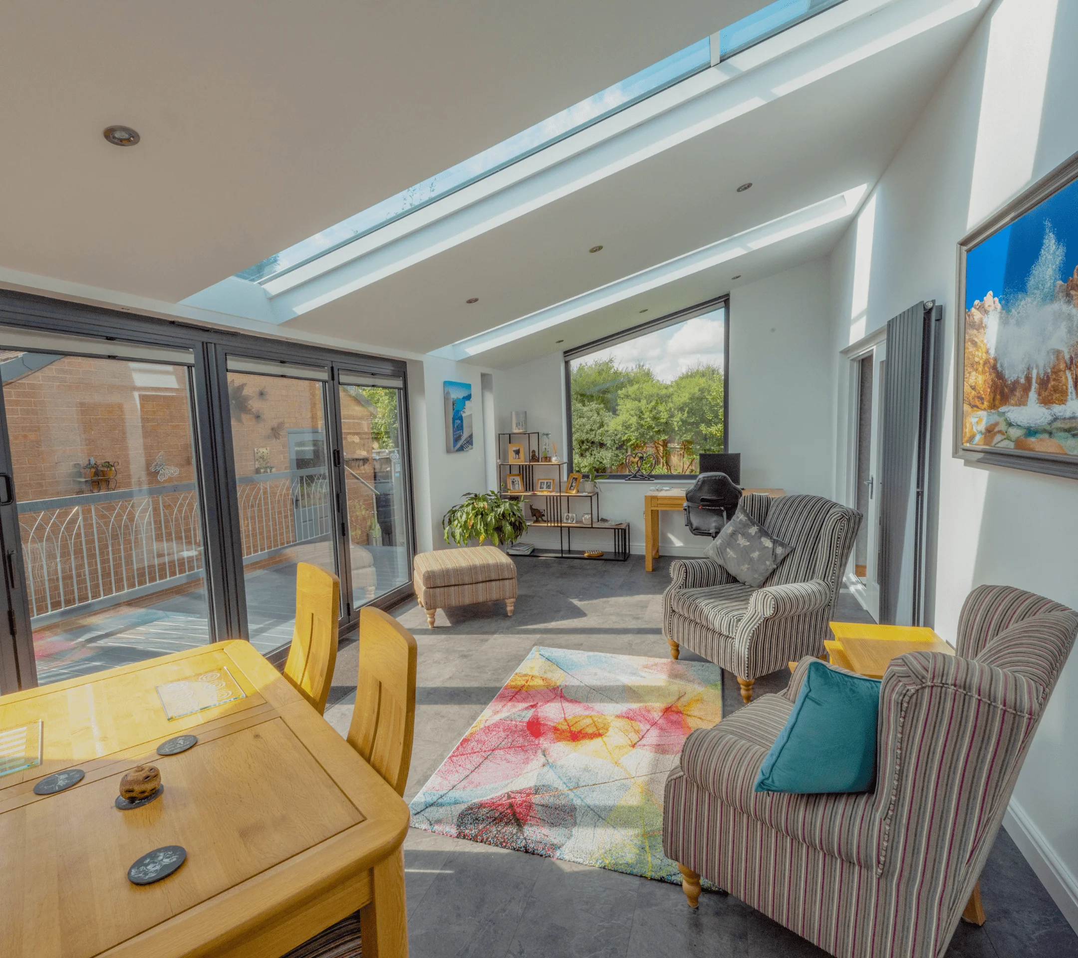 Stripey chairs and footstool with oak dining table set in converted conservatory extension