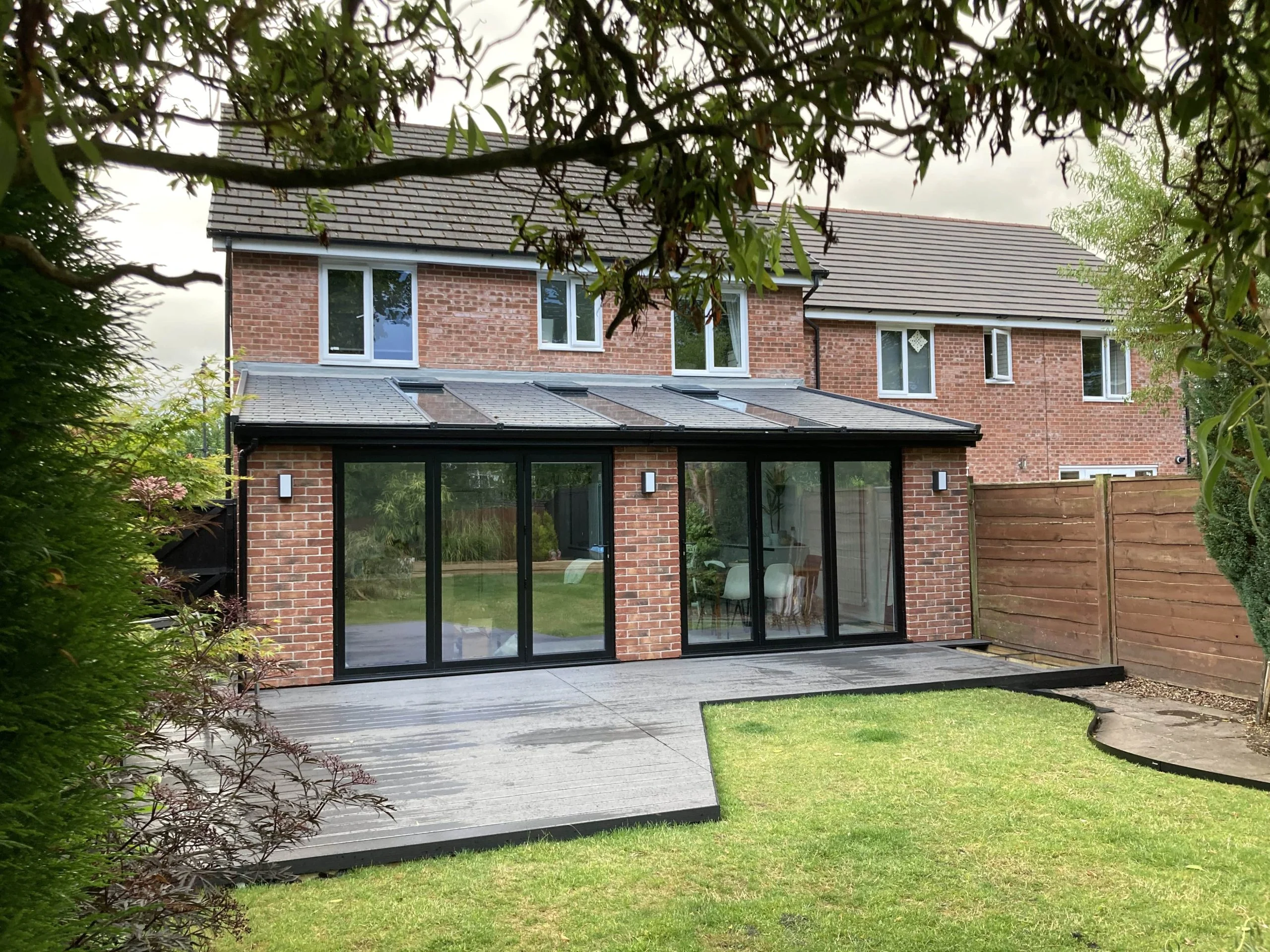 Rear of house with brick walls and black frame bi-fold doors