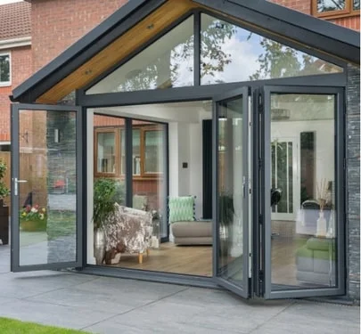 UK conservatory with large glass bi-folding doors in black