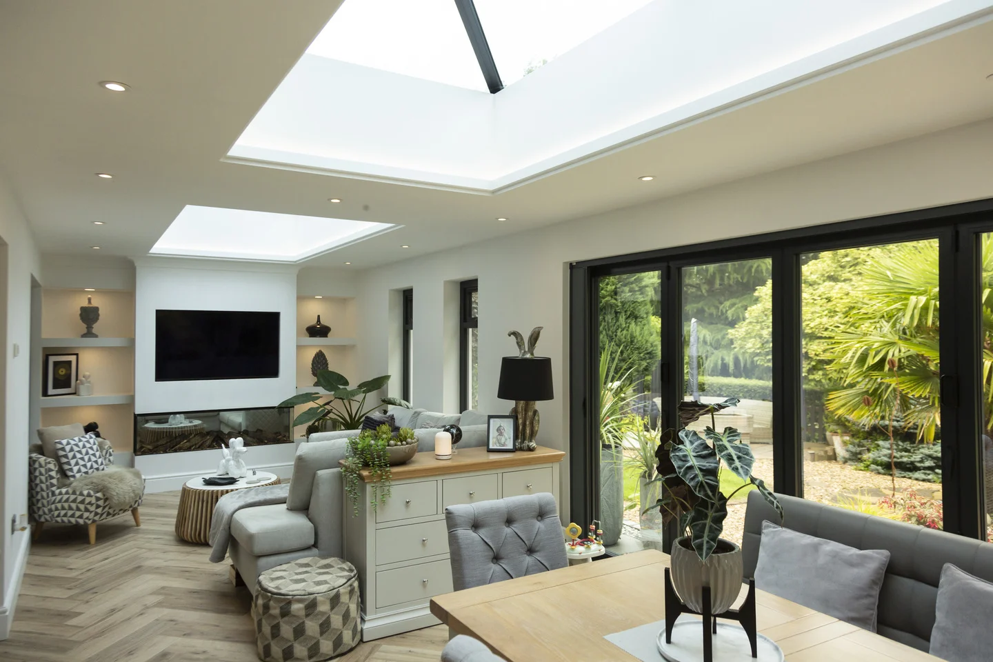 Wide home extension with grey furniture and oak table