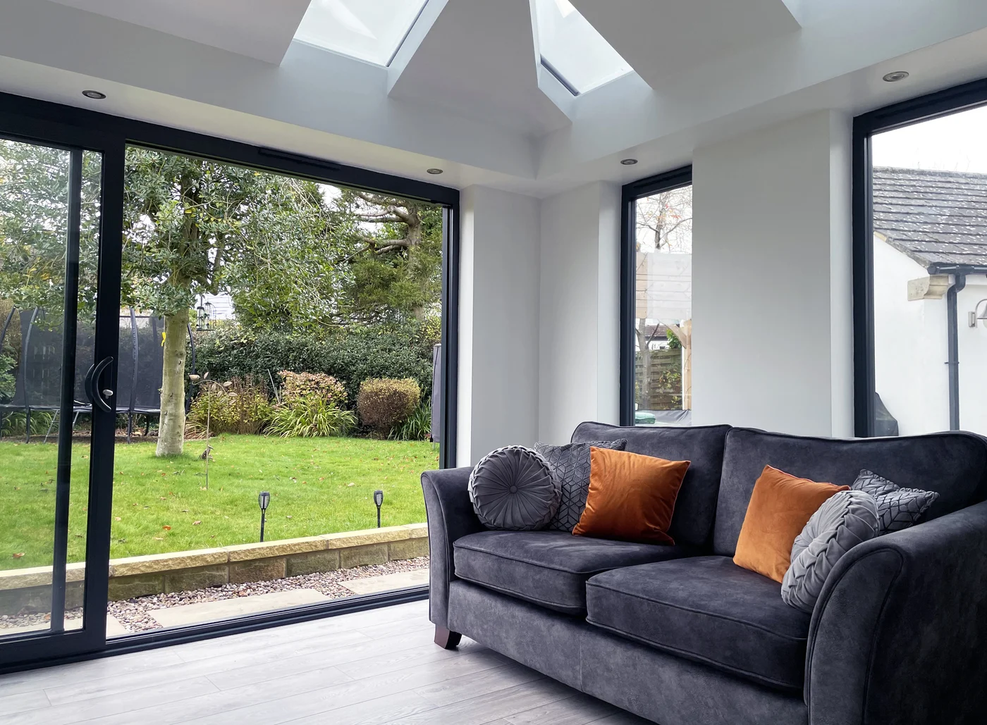 Glass sliding door with black frame leading to cosy lounge room
