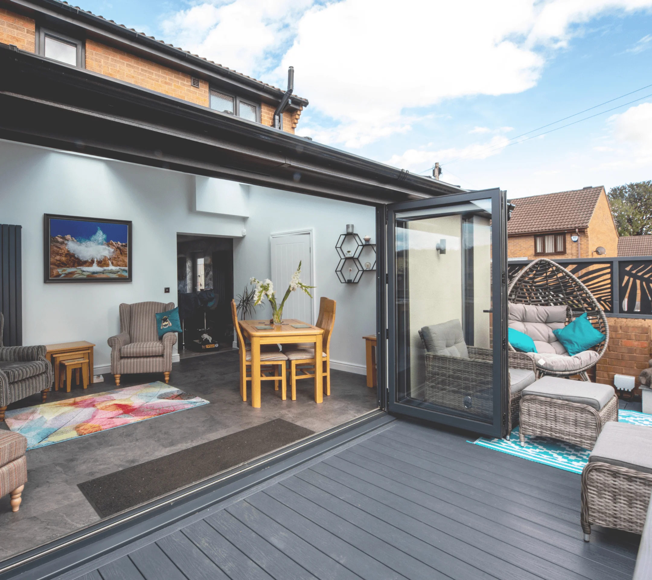 Glass bi-folding door with black frame leading to open lounge room