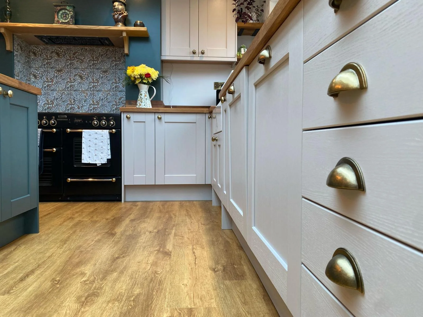 Close view of cream kitchen counters and cupboards with bronze metal handles