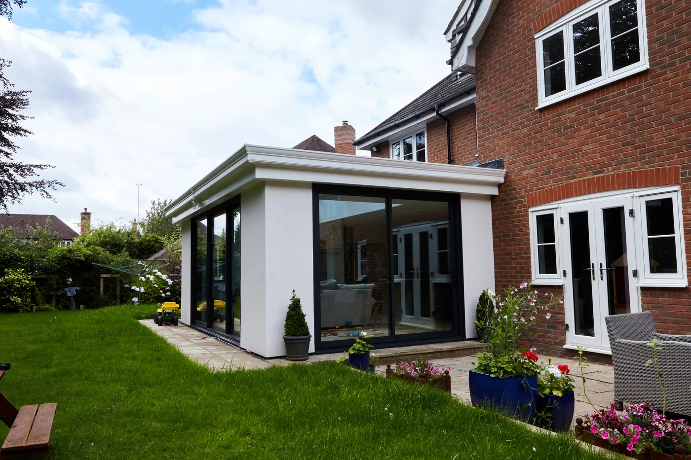 UK orangery conversion with white rendering and flat roof