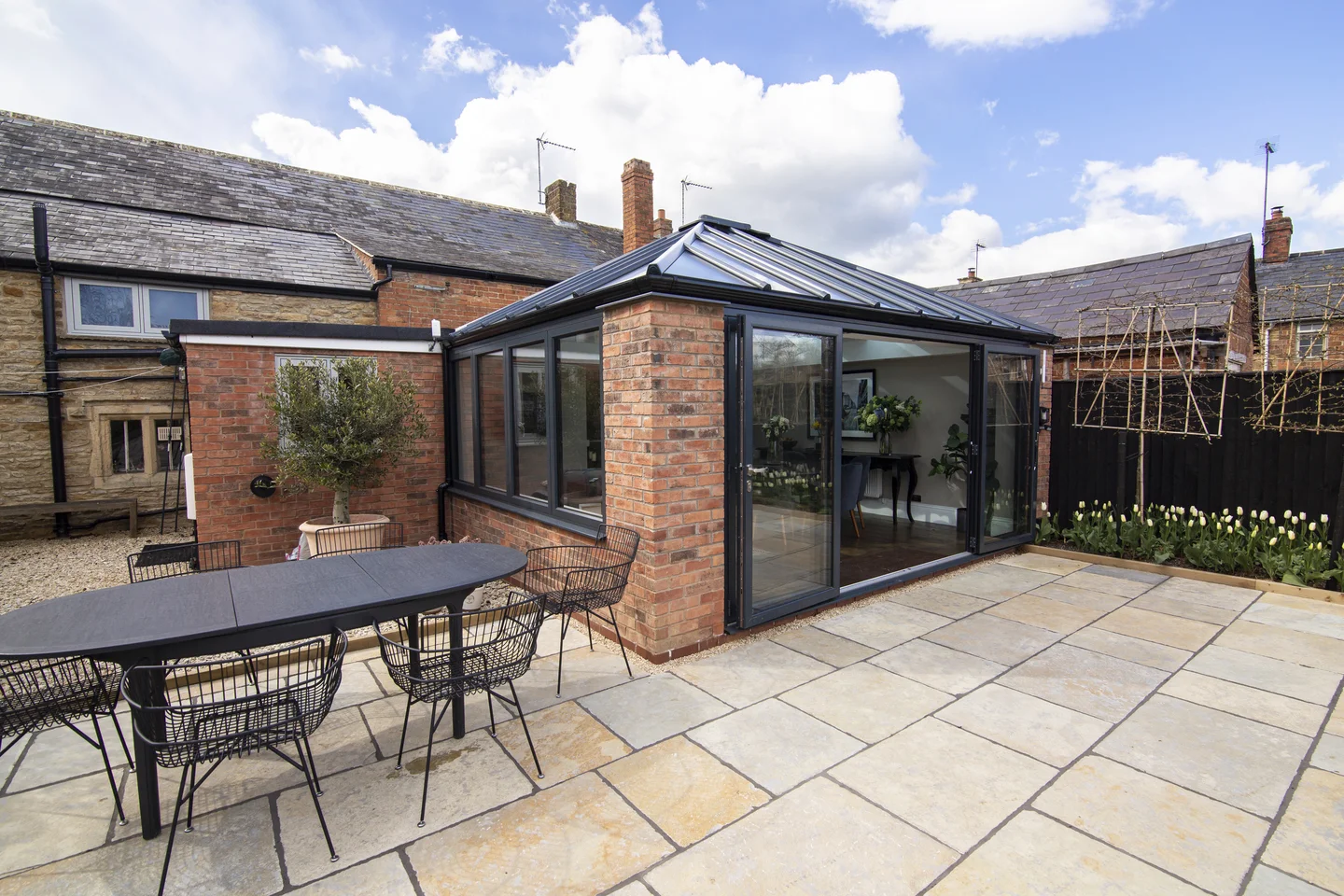 UK garden patio with neutral colour garden tiles and sleek house extension