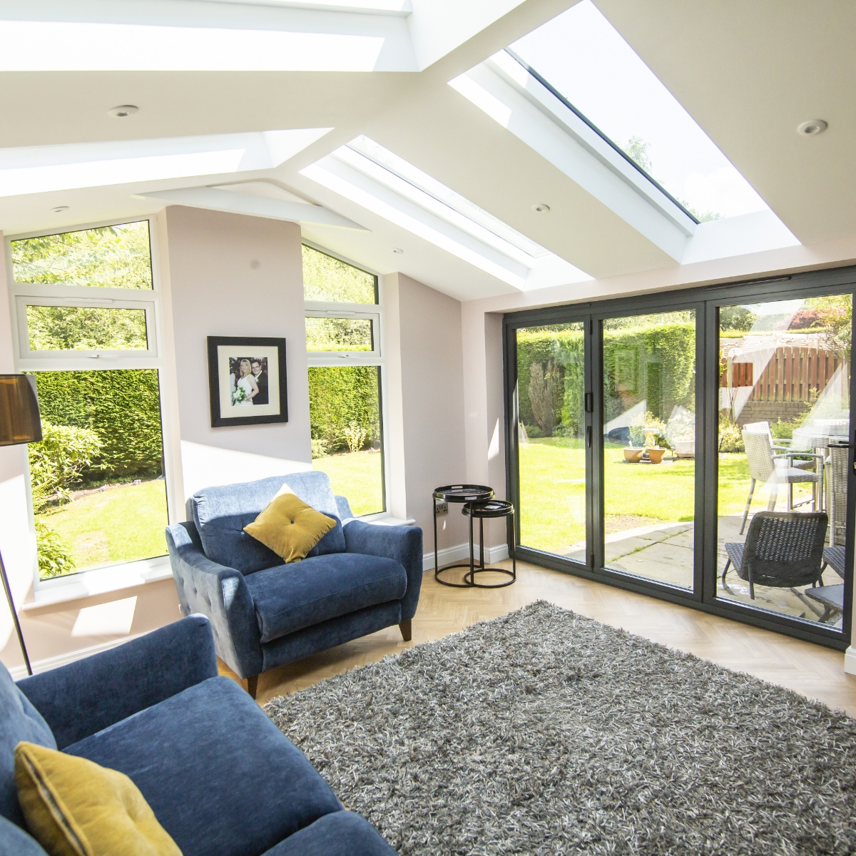 Bright living room with hybrid glass roof and blue sofas