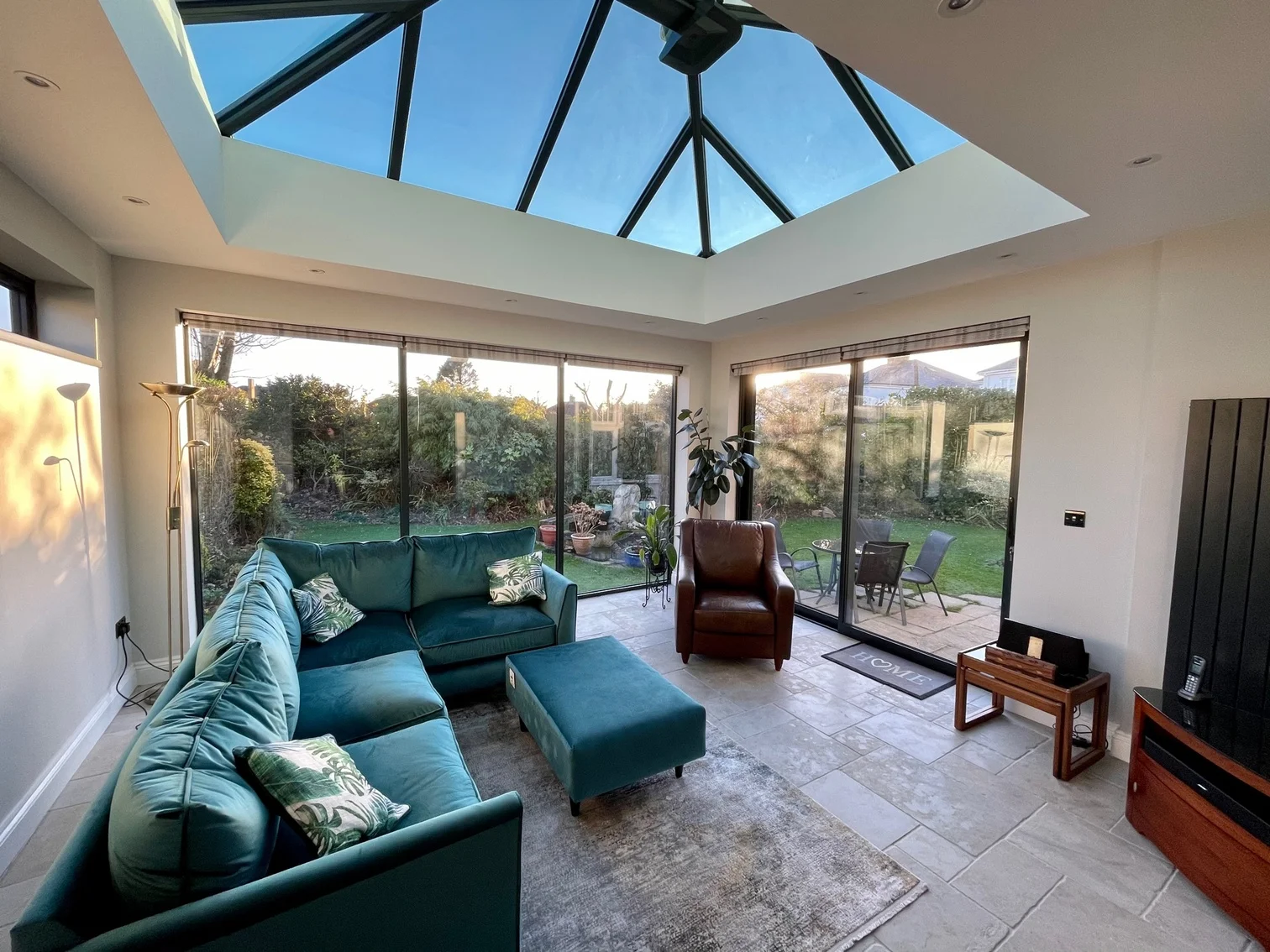 Modern orangery home conversion with teal l-shape sofa