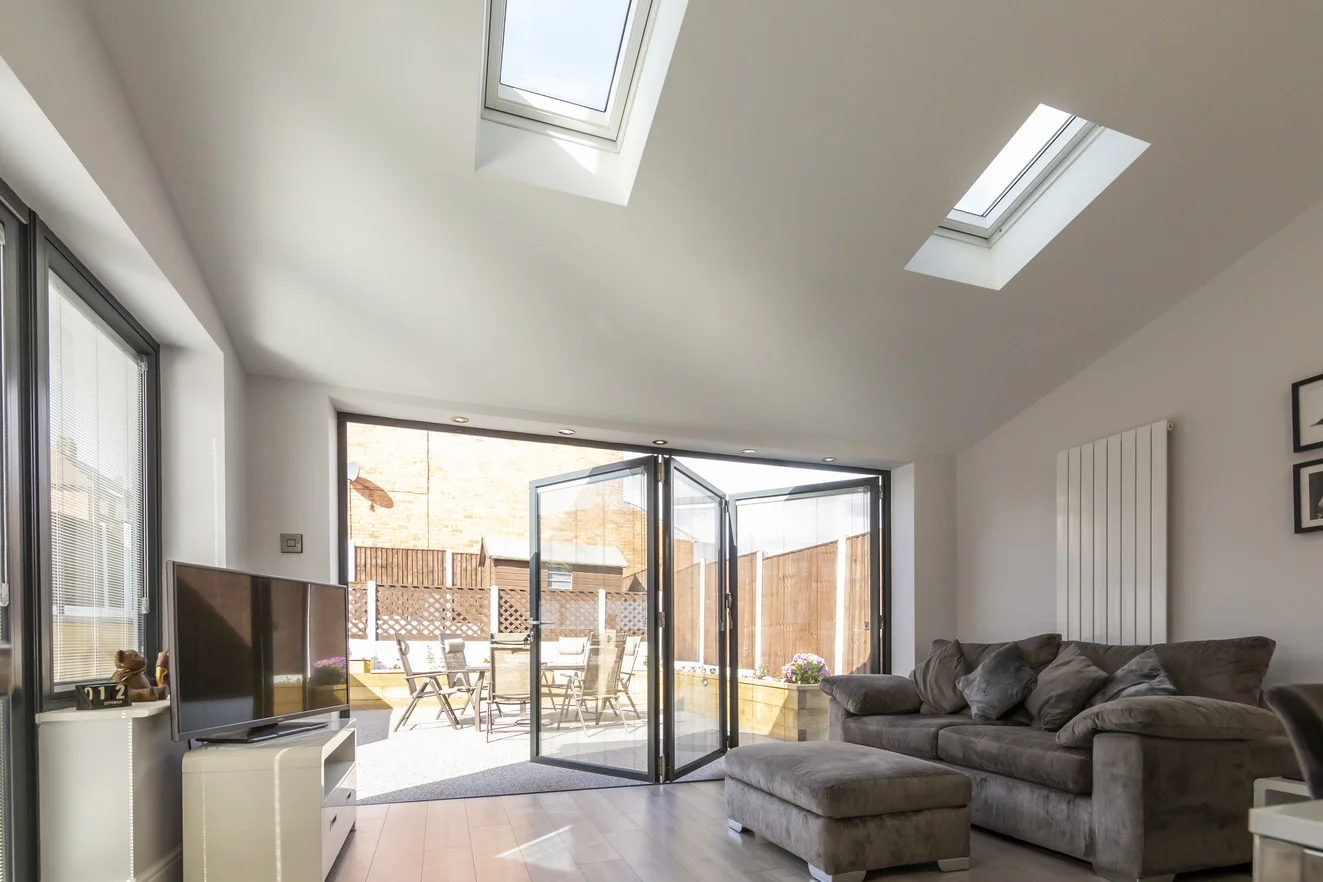 UK terraced house with grey sofa and opened bi-fold doors