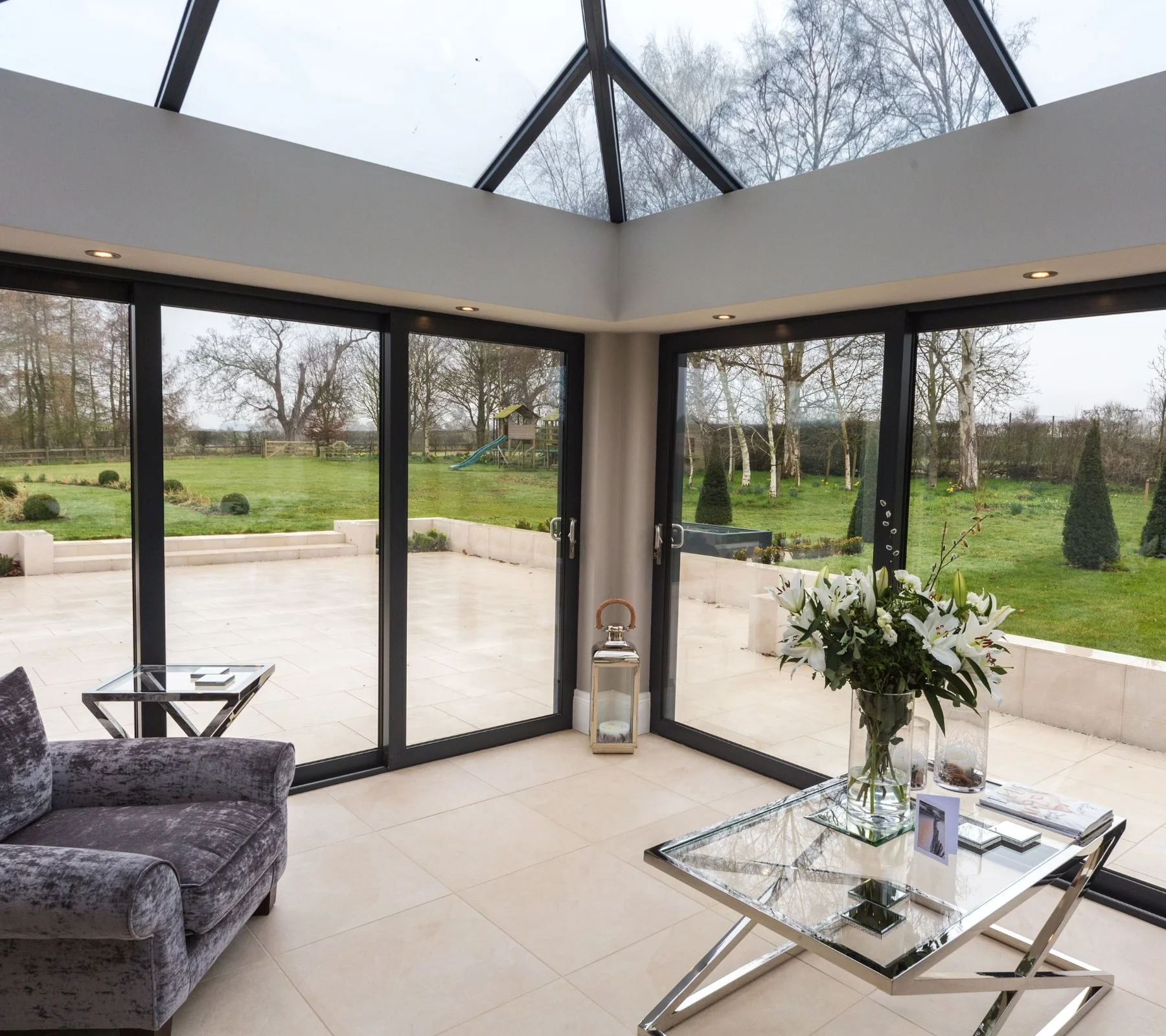 Spacious orangery in British home with large glass roof and bi-fold doors