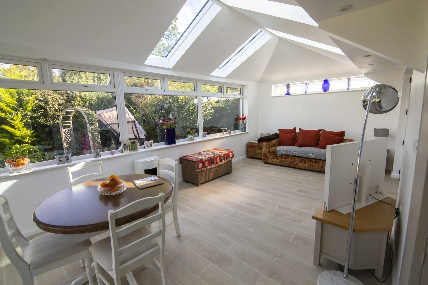 Simple lounge with sofa, small round dining table and glass roof panels