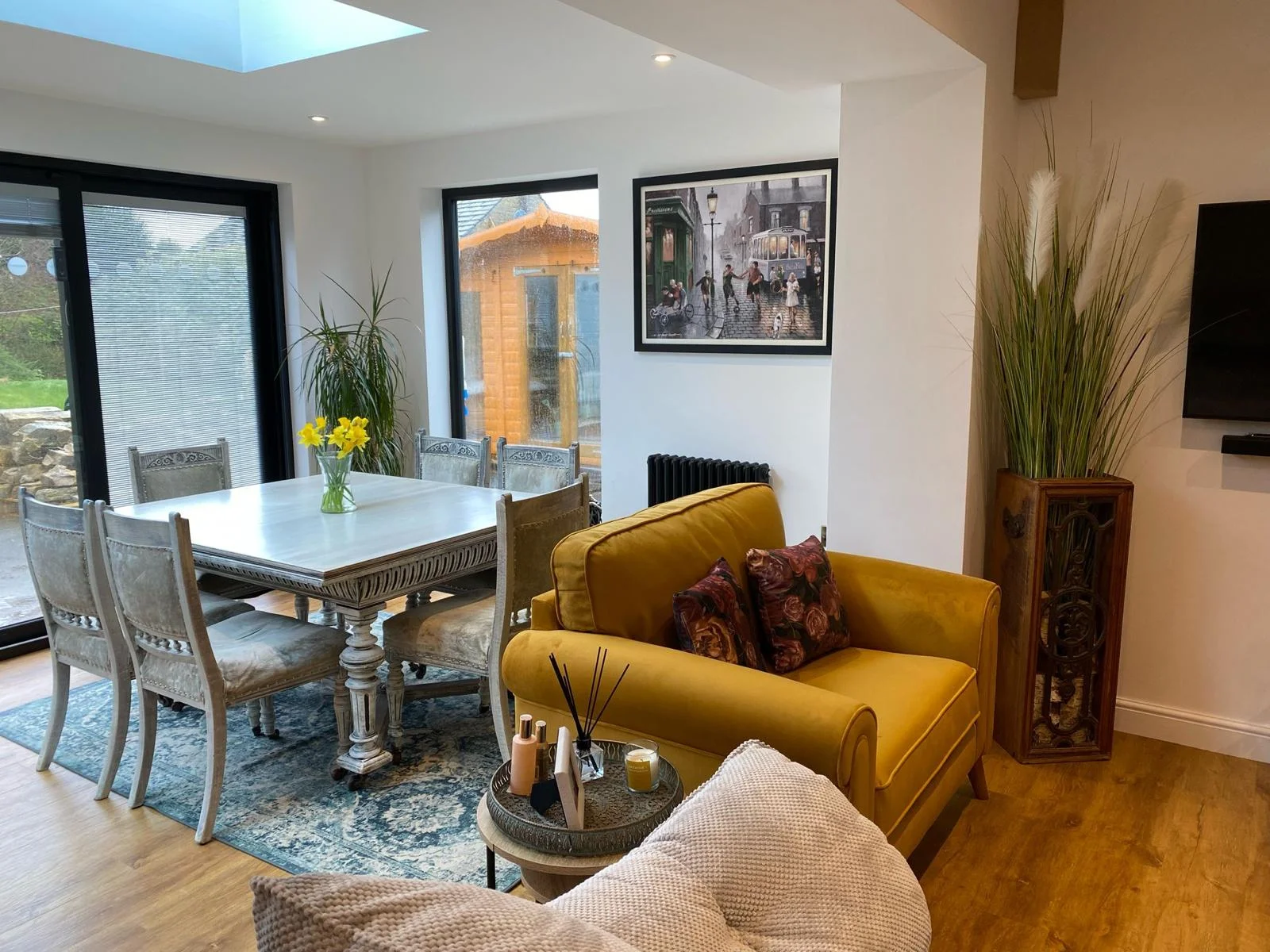 Cosy home interior with dining table and yellow velvet finish sofa