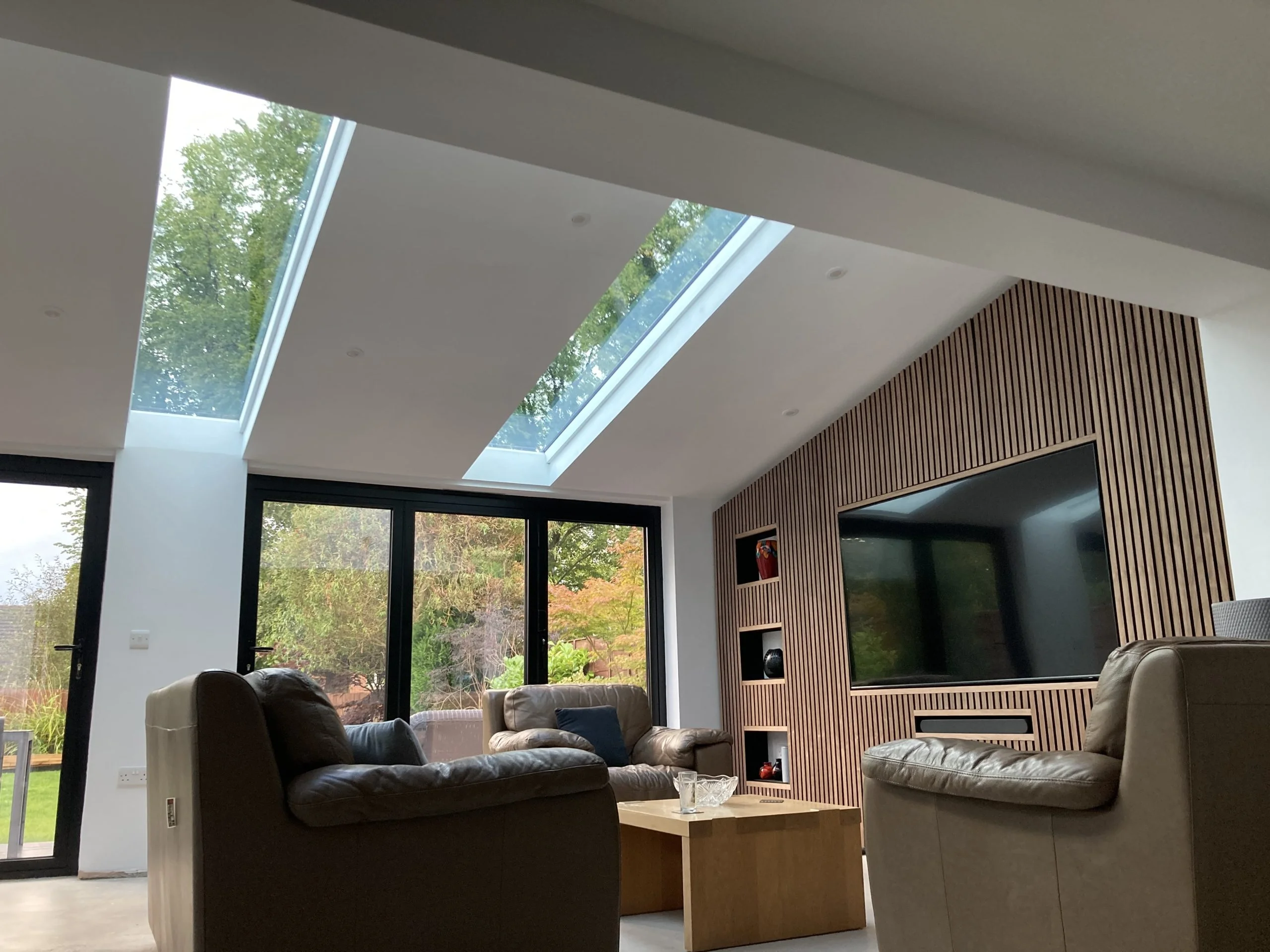 Media wall with wooden wall panelling in UK home extension